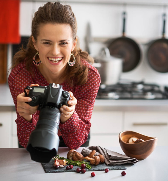 Smiling woman food photographer looking up from food - Фото, изображение