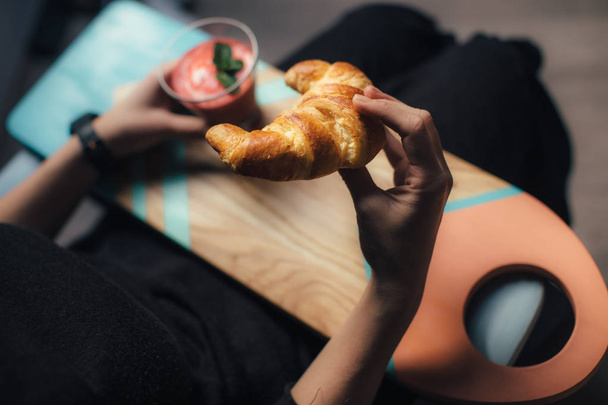 Woman eating croissant - Фото, изображение
