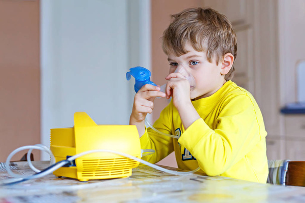 Cute kid boy making inhalation therapy by the mask of inhaler - Photo, image