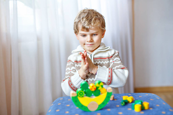 Jongen jongen spelen met houten evenwicht speelgoed thuis - Foto, afbeelding