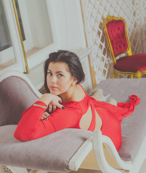 on the couch sexy girl in a red dress - Fotografie, Obrázek