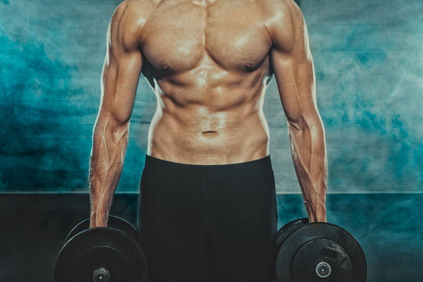 Young man standing with dumbbells - Photo, Image