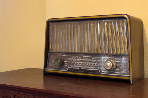 Wood vintage antique analog radio with radio dial on wooden table. - Photo, Image