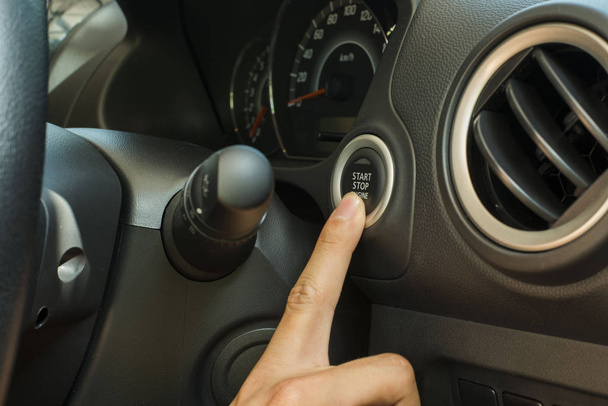 Палець натискає кнопку запуску і зупинки для сучасного автомобіля Eco
 - Фото, зображення