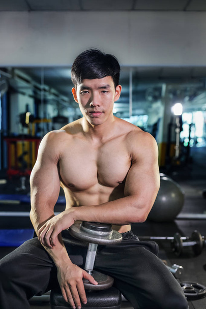 Handsome asian man with dumbbell  in the gym - Фото, зображення