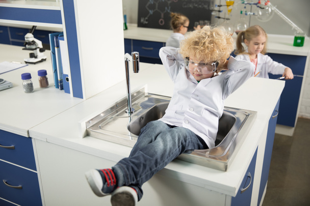 Boy sitting in sink - Фото, зображення