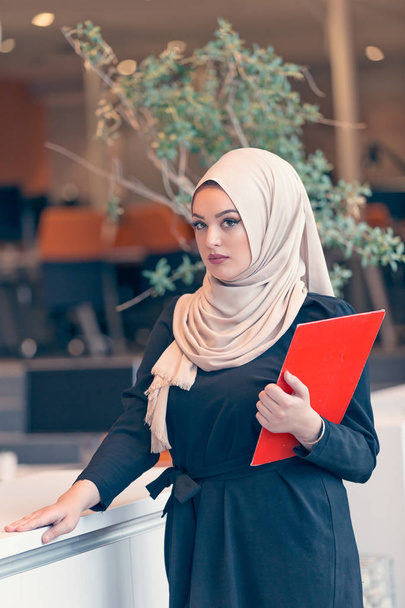 Arabian business woman holding a folder - Фото, зображення