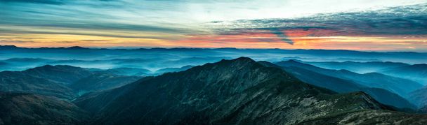 Πανόραμα με μπλε βουνά και λόφοι στο ηλιοβασίλεμα - Φωτογραφία, εικόνα