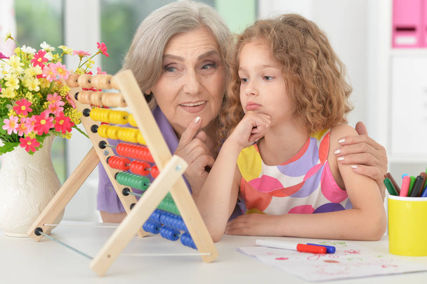 grandmother helping her granddaughter doing homework - Фото, зображення