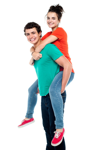 Handsome young man giving a piggyback ride to his girlfriend - Φωτογραφία, εικόνα