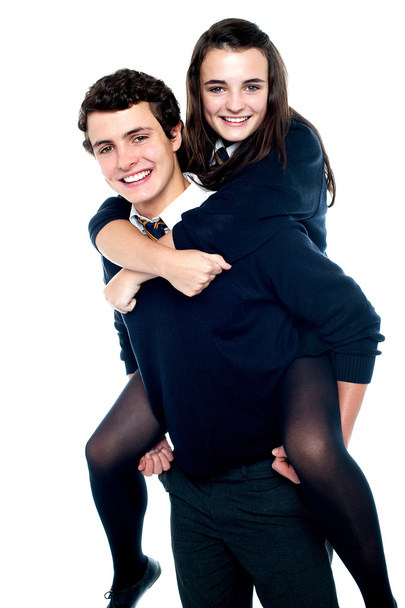 Girl riding piggyback and embracing boy tightly - Foto, imagen