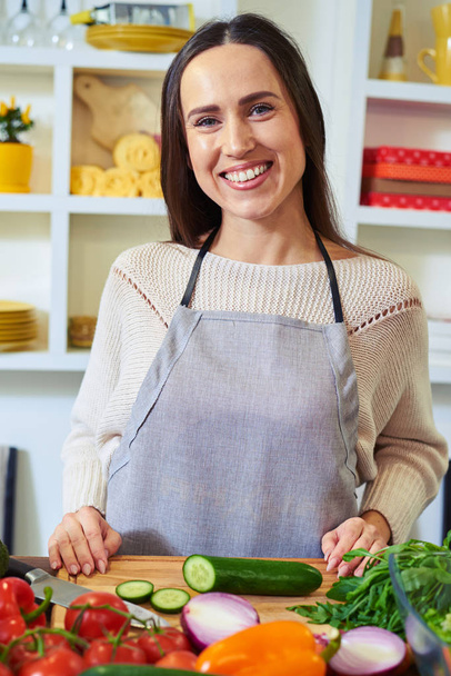 Pretty Caucasian woman wearing an apron posing at the camera in  - Photo, Image