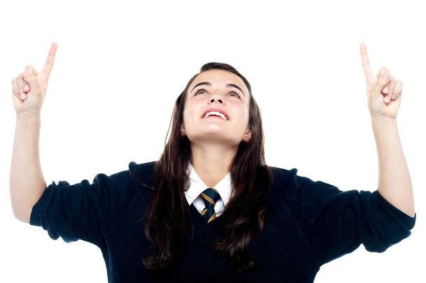 Excited young teenage girl looking and pointing upwards - Foto, Imagem