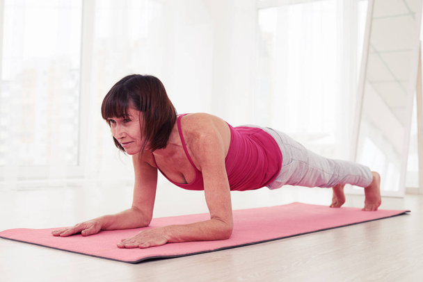 Sporty woman doing plank pose in the gym  - Photo, image