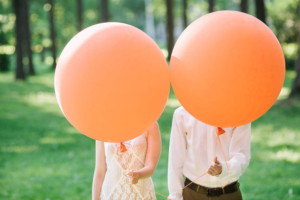 newlyweds with orange balloons. the amusing photo with newlyweds. - 写真・画像