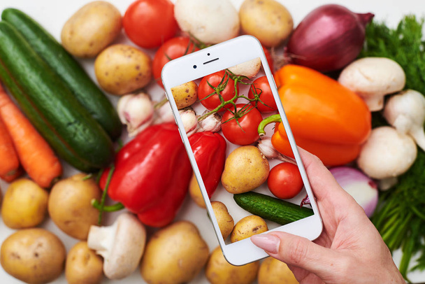 Vue du dessus du téléphone prend des photos de légumes frais
  - Photo, image