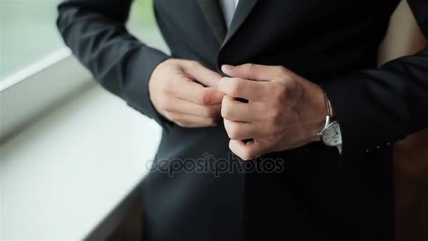Stylish man dressed in suit buttoning jacket close up. Male hands of confident gentleman adjust outfit preparing for formal evening. Image establishment leadership lifestyle masculinity style success - Πλάνα, βίντεο