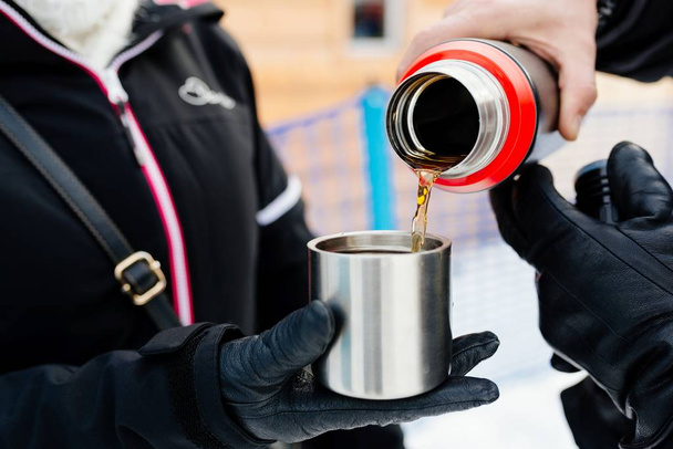 Man pouring hot tea from a thermos - Foto, Bild