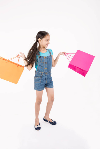 jonge vrouwelijke meisje winkelen op witte achtergrond - Foto, afbeelding