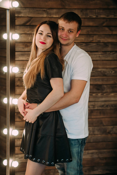 Portrait of young couple in love posing at studio dressed in classic clothes - Photo, Image