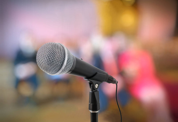Speech or conference concept. Microphone on stand in front of audience. - Photo, Image
