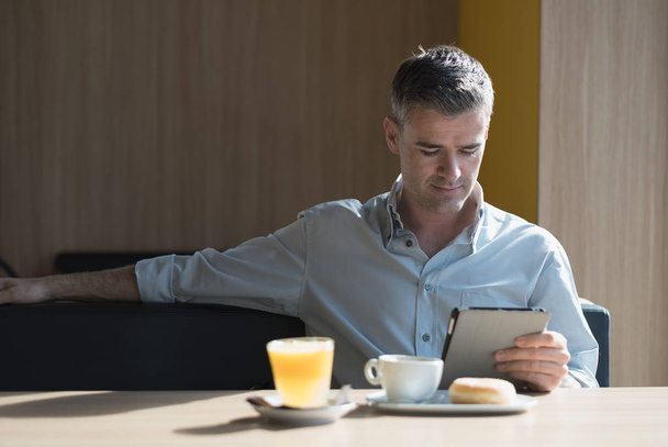 Businessman sitting with tablet - Valokuva, kuva