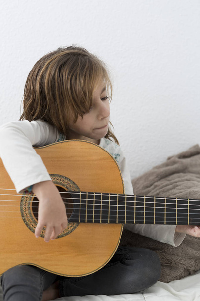 Bambina che impara a suonare la chitarra classica
 - Foto, immagini