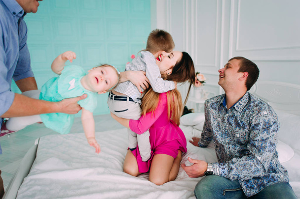 Kaunis perheen muotokuva viettää aikaa yhdessä studiossa
 - Valokuva, kuva