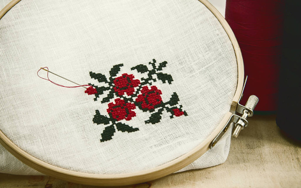 Ручная вышивка крест-стежок цветочный орнамент на белой ткани
 - Фото, изображение
