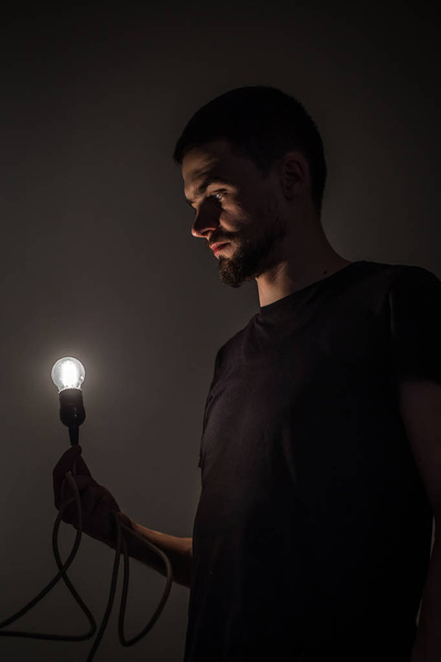 muž s žárovky na černém pozadí - Fotografie, Obrázek