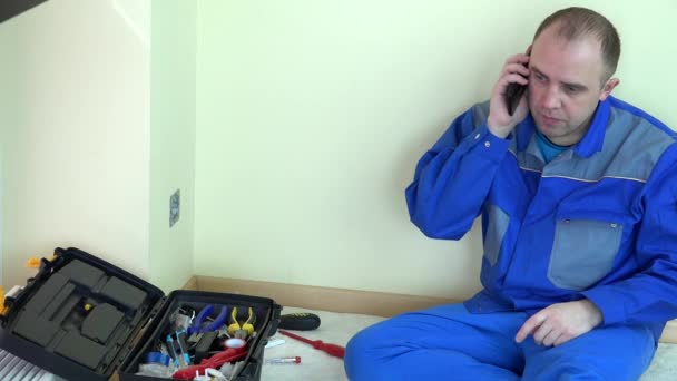 Moe elektricien werknemer man praten moderne mobiele telefoon - Video