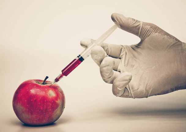 ręka iniekcji chemicznych do apple - Zdjęcie, obraz