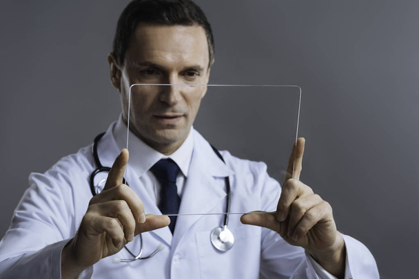 Handsome doctor holding special glass - Zdjęcie, obraz