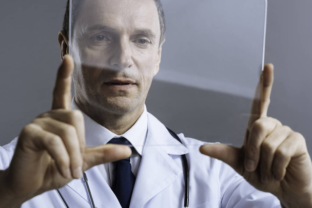Attentive doctor looking at medical glass - Fotó, kép