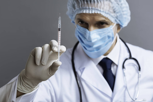 Delighted doctor holding hypodermic needle - Foto, Imagen