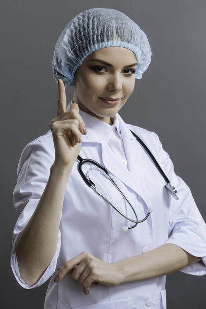 Female young doctor gesturing with her finger - Фото, изображение