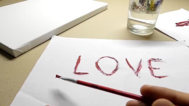 Ręczne malowanie 'miłość' i linia pod nim na arkuszu papieru - Materiał filmowy, wideo