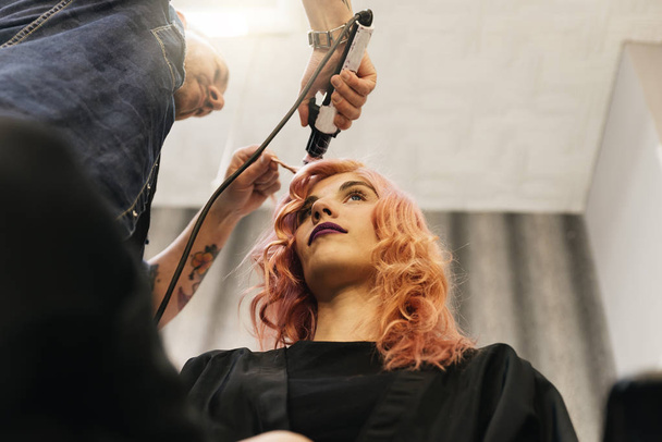 Beautiful woman getting haircut by hairdresser. - Photo, image