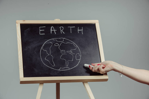 earth written on blackboard with earth symbol, background, high resolution, gray background - Foto, Bild