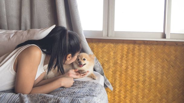 Woman relax with dog in bedroom. - Foto, Bild