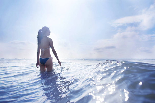 Hullámok a tengerparton álló nő - Fotó, kép