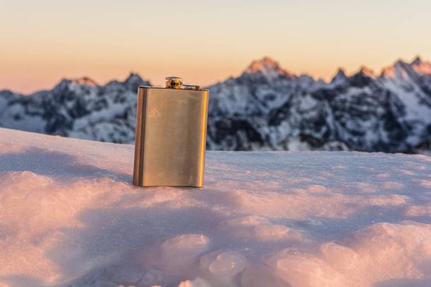 Hip flask on a background of mountains. - Photo, Image