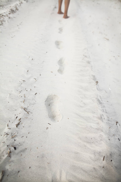 Persona que deja huellas en la arena de la playa
 - Foto, imagen