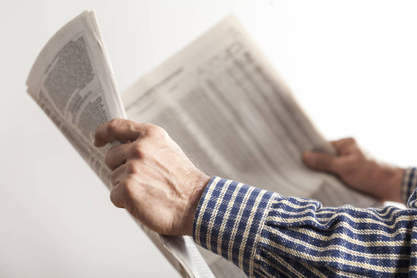 Hombre leyendo periódico sobre fondo gris
 - Foto, Imagen