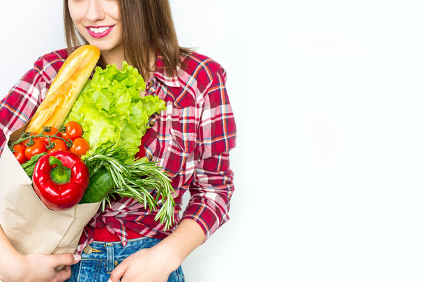 Beautiful smiling woman holding shopping paper bag with organic fresh food - Фото, зображення