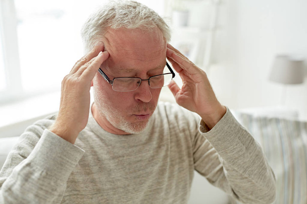 Hombre mayor que sufre de dolor de cabeza en casa
 - Foto, imagen