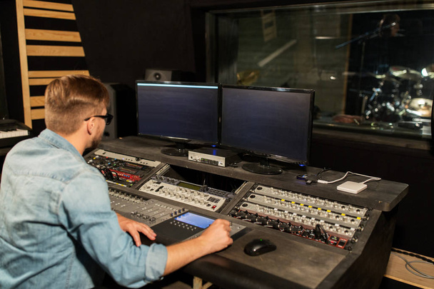 man at mixing console in music recording studio - Zdjęcie, obraz