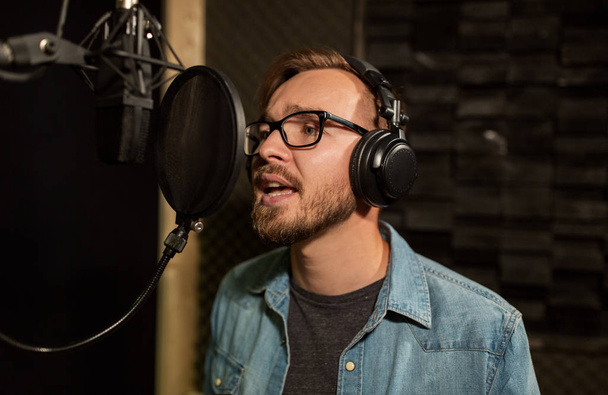 man with headphones singing at recording studio - Foto, Imagem