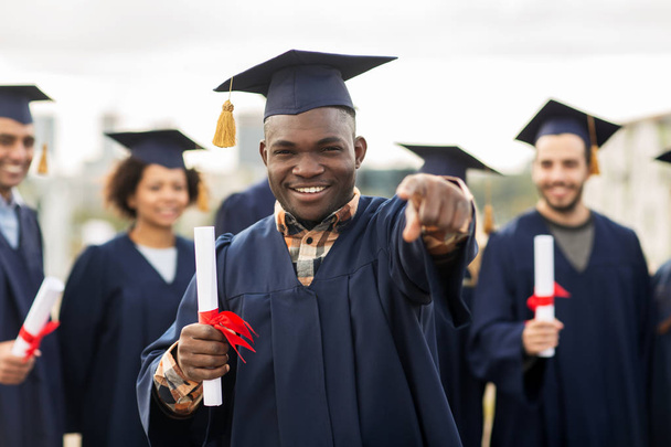 happy student with diploma pointing finger at you - Foto, immagini