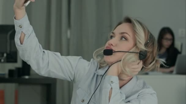 Bored secretary taking selfies with phone during work time - Кадри, відео
